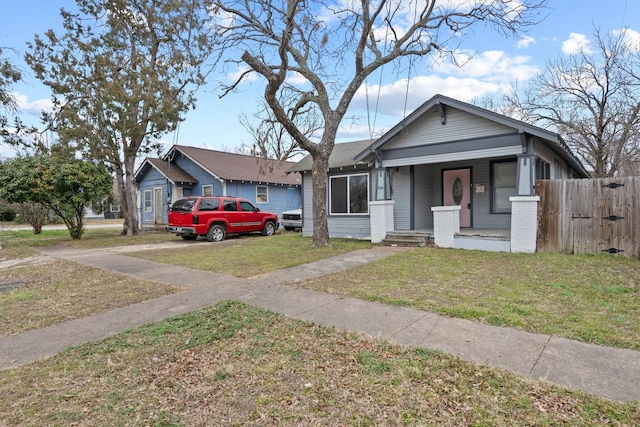 bungalow-style house featuring a front lawn and covered porch