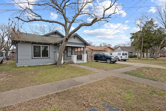 bungalow-style home with covered porch and a front lawn