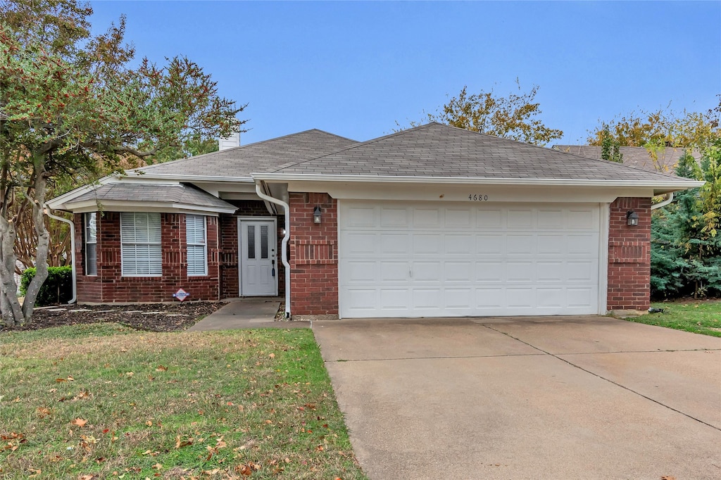 ranch-style home with a garage and a front lawn