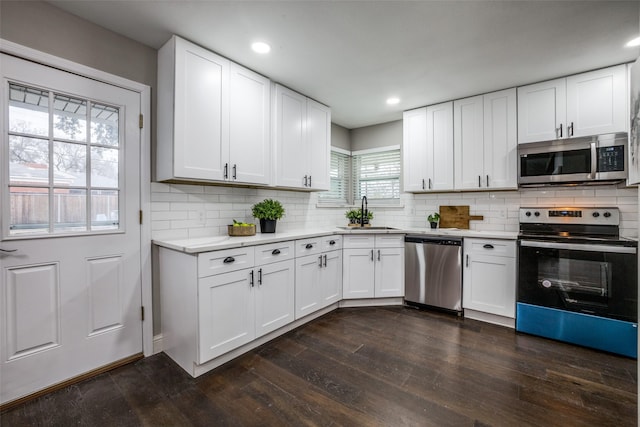 kitchen featuring sink, stainless steel appliances, white cabinetry, and dark hardwood / wood-style floors