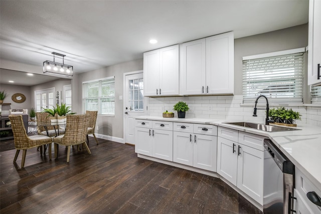 kitchen featuring pendant lighting, dishwasher, sink, white cabinets, and dark wood-type flooring