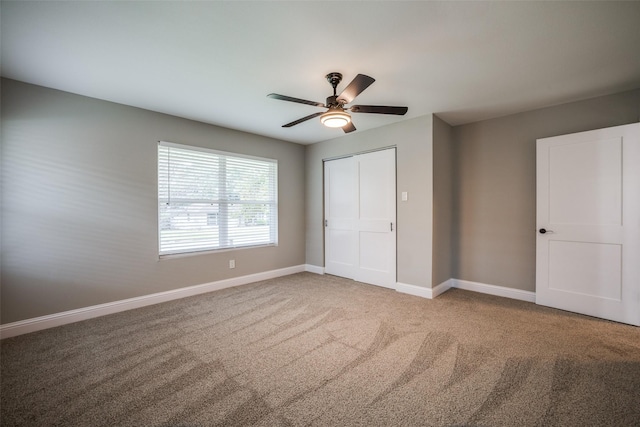 unfurnished bedroom featuring ceiling fan, a closet, and carpet floors