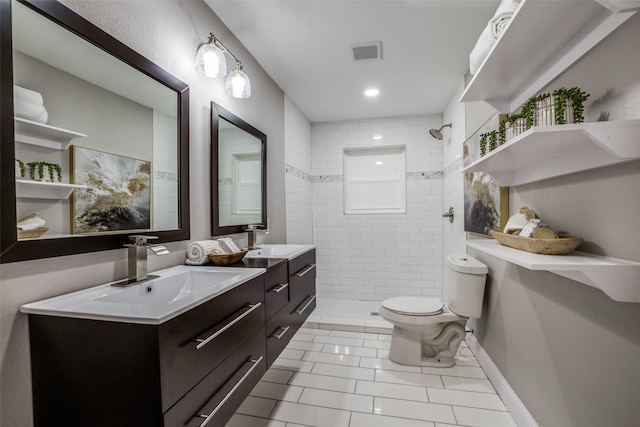 bathroom with a tile shower, toilet, tile patterned floors, and vanity