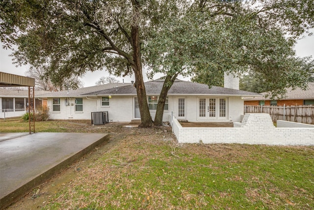 rear view of house featuring a patio area, a yard, and french doors