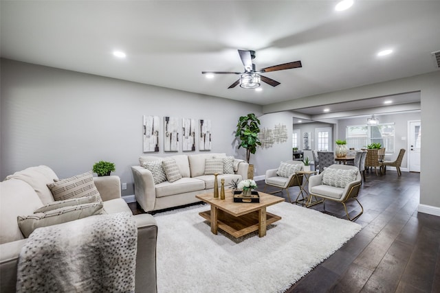 living room featuring ceiling fan and dark hardwood / wood-style flooring