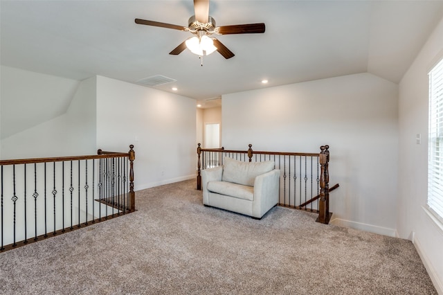 living area with vaulted ceiling, a healthy amount of sunlight, and light carpet