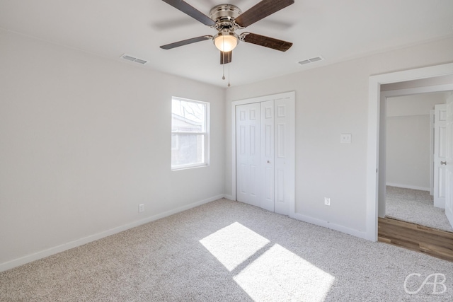 unfurnished bedroom with ceiling fan, light colored carpet, and a closet