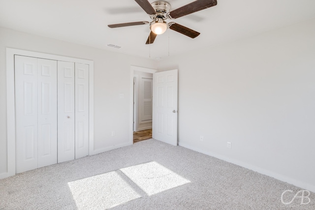 unfurnished bedroom with ceiling fan, a closet, and carpet floors