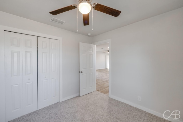 unfurnished bedroom featuring a closet, ceiling fan, and light colored carpet