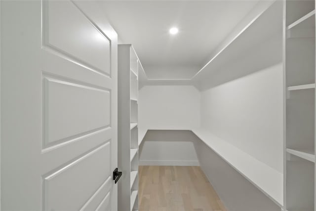 walk in closet with light hardwood / wood-style floors