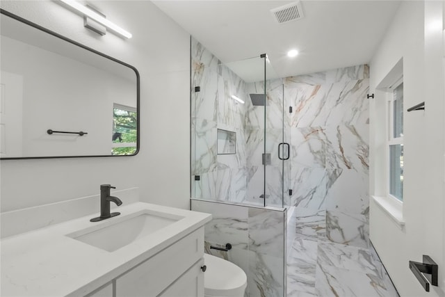 bathroom with toilet, a shower with door, and vanity