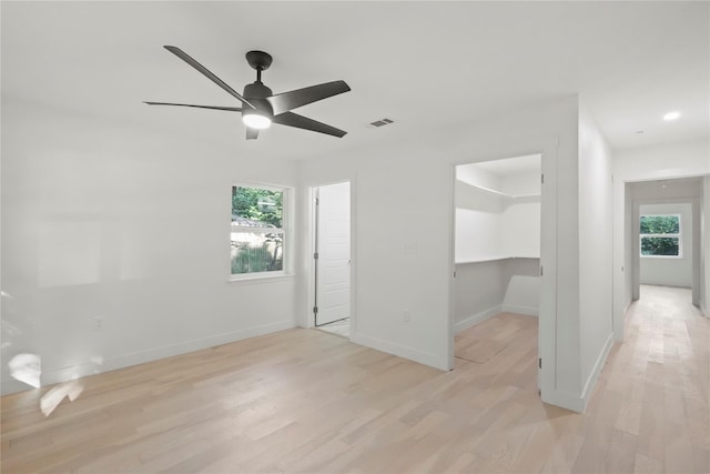 empty room featuring a healthy amount of sunlight, light wood-type flooring, and ceiling fan