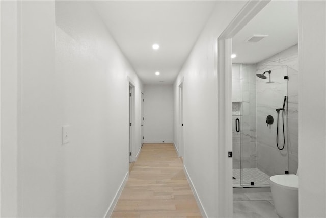 bathroom with hardwood / wood-style floors, toilet, and an enclosed shower