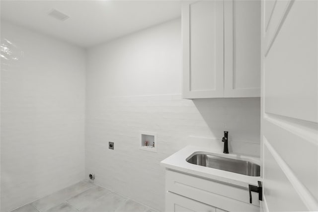 laundry room with sink, hookup for a washing machine, electric dryer hookup, cabinets, and light tile patterned flooring