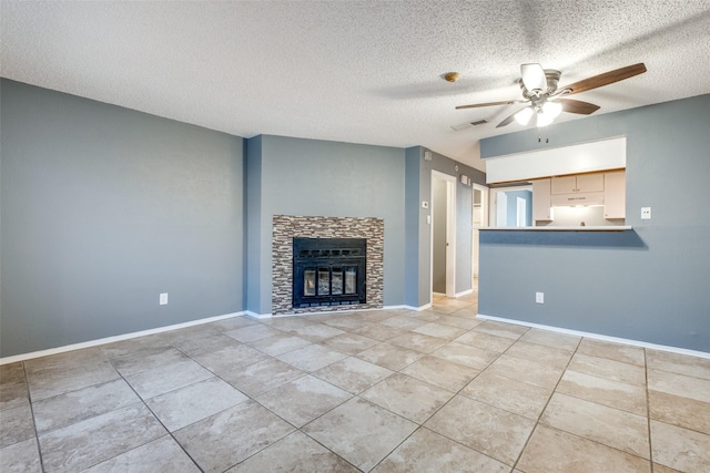 unfurnished living room with a fireplace, a textured ceiling, light tile patterned floors, and ceiling fan