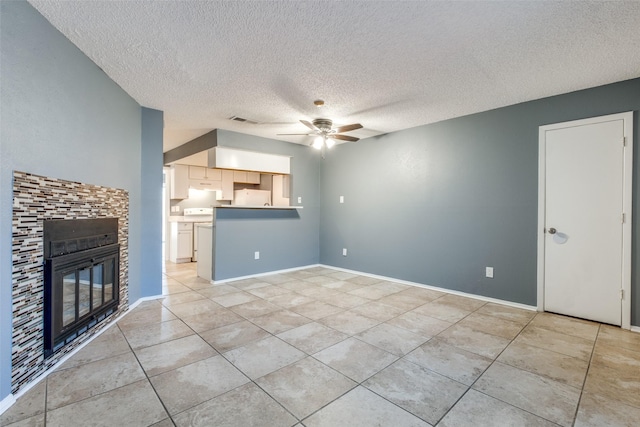 unfurnished living room with a textured ceiling, light tile patterned floors, and ceiling fan