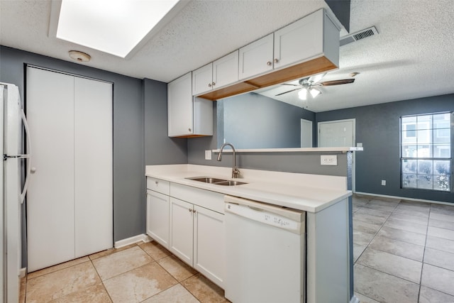 kitchen with white cabinetry, sink, white appliances, and a textured ceiling