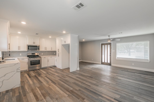 kitchen featuring light stone countertops, tasteful backsplash, sink, white cabinets, and stainless steel appliances