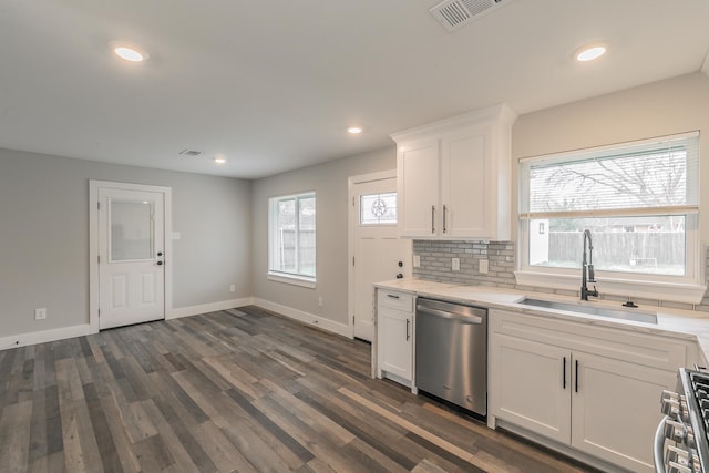 kitchen with dark hardwood / wood-style flooring, sink, backsplash, white cabinetry, and stainless steel appliances