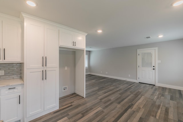 kitchen with decorative backsplash, dark wood-type flooring, white cabinetry, and light stone counters