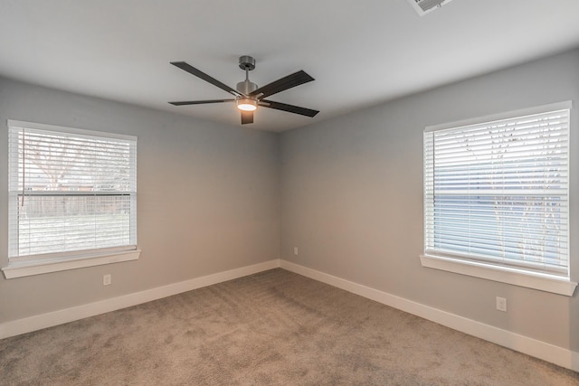 carpeted spare room with ceiling fan and a wealth of natural light