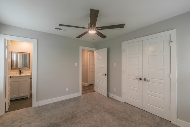 unfurnished bedroom featuring ceiling fan, a closet, ensuite bath, and carpet floors