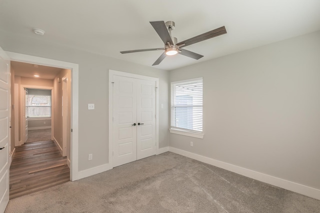 unfurnished bedroom featuring carpet floors, a closet, and ceiling fan