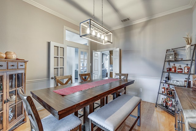 dining room featuring ornamental molding and light hardwood / wood-style floors