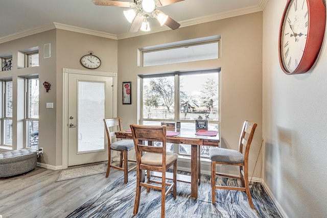 dining area with ornamental molding, plenty of natural light, wood-type flooring, and ceiling fan