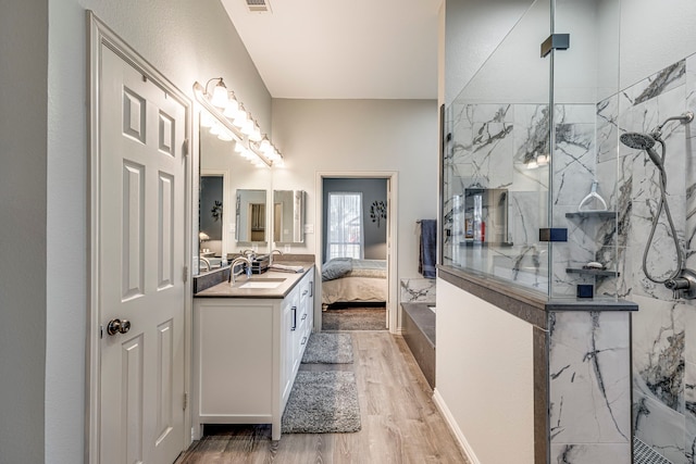 bathroom with walk in shower, wood-type flooring, and vanity