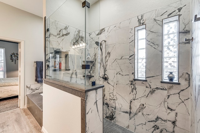 bathroom with hardwood / wood-style flooring and a tile shower