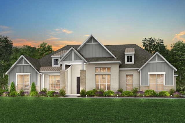 craftsman house featuring brick siding, board and batten siding, a front yard, and a shingled roof