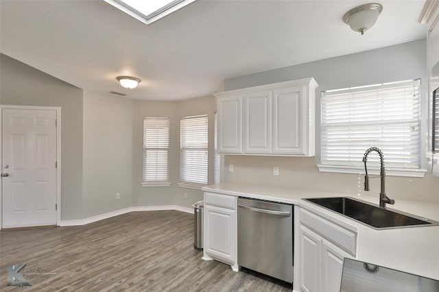 kitchen with sink, white cabinetry, stainless steel dishwasher, and light hardwood / wood-style flooring