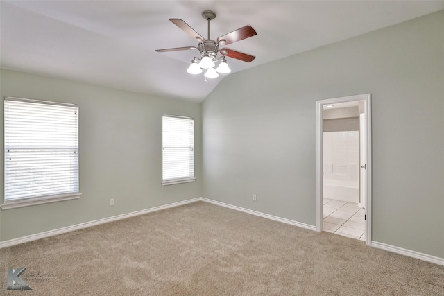 spare room with ceiling fan, light colored carpet, and lofted ceiling