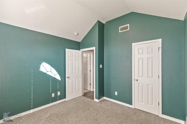 unfurnished bedroom featuring carpet floors and lofted ceiling