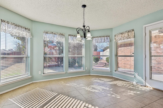 unfurnished dining area featuring tile patterned floors and plenty of natural light