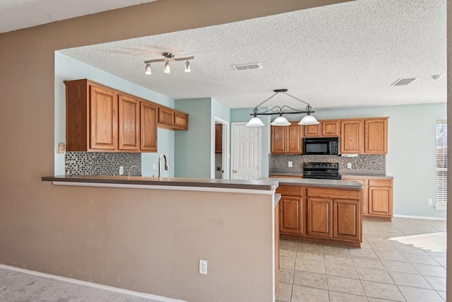 kitchen featuring pendant lighting, tasteful backsplash, sink, black appliances, and a textured ceiling