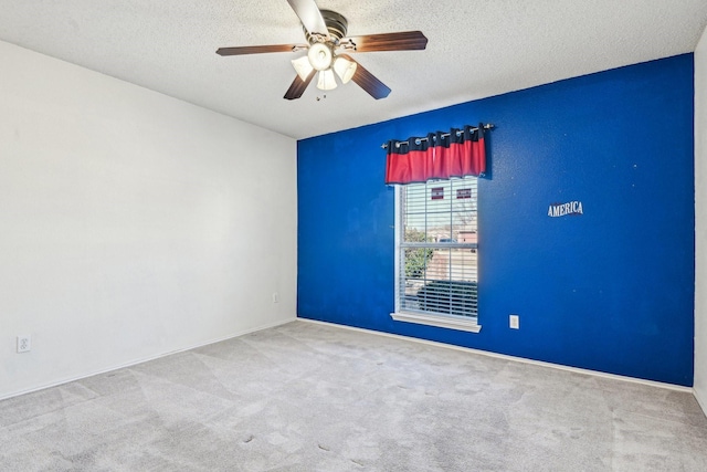 carpeted spare room with ceiling fan and a textured ceiling