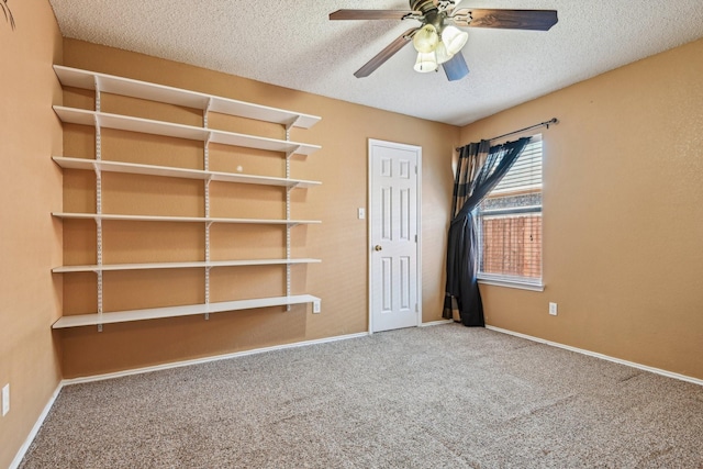 carpeted spare room with ceiling fan and a textured ceiling