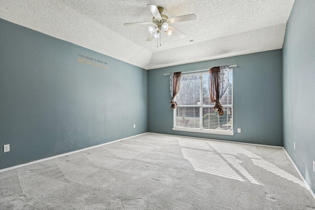 unfurnished room with ceiling fan, light colored carpet, vaulted ceiling, and a textured ceiling