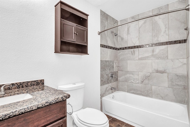 full bathroom featuring tiled shower / bath, vanity, and toilet