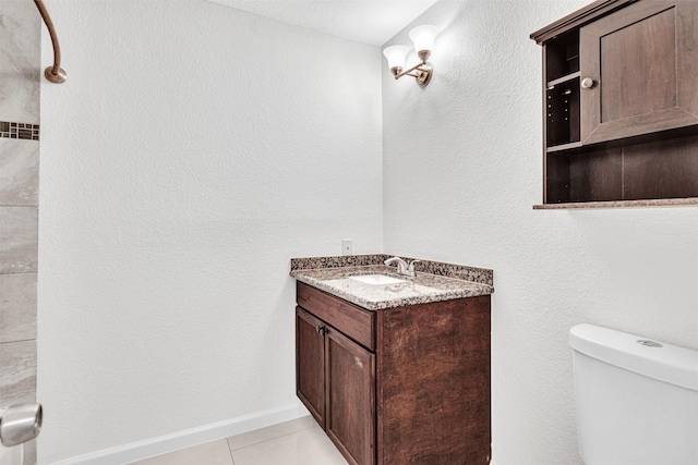 bathroom featuring vanity, tile patterned floors, and toilet