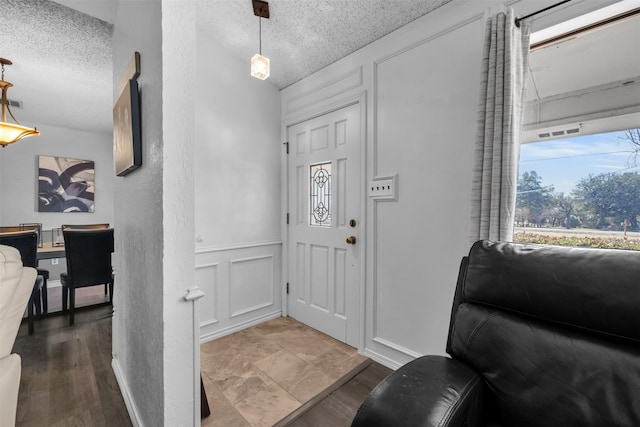 foyer with wood-type flooring and a textured ceiling