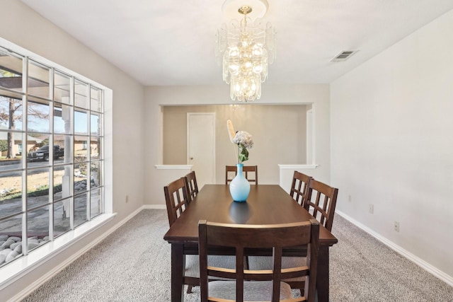 dining space with a chandelier and carpet