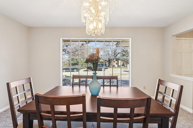 carpeted dining room featuring a notable chandelier