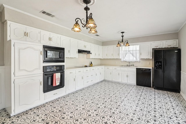 kitchen featuring pendant lighting, white cabinets, black appliances, and a notable chandelier