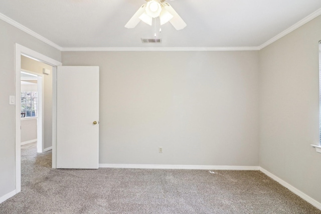 carpeted spare room with ceiling fan and ornamental molding