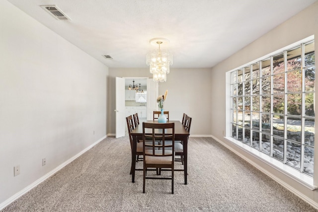 dining area with a chandelier and carpet floors