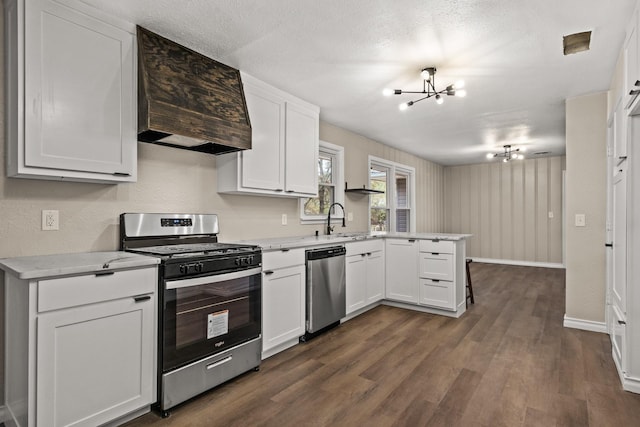 kitchen featuring white cabinets, kitchen peninsula, an inviting chandelier, stainless steel appliances, and dark hardwood / wood-style floors