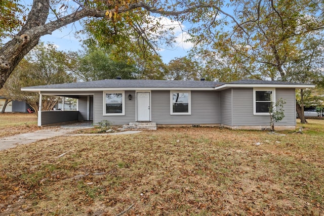 ranch-style house with a front yard and a carport